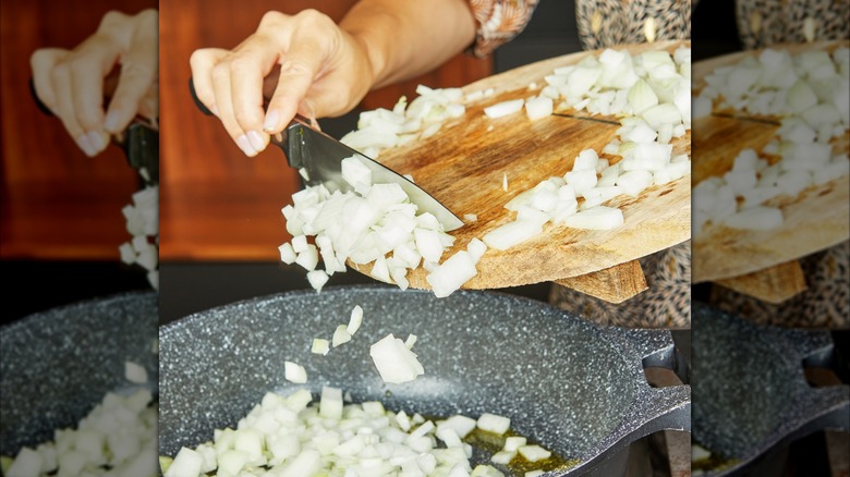 A woman scraping diced onions with a knife from a cutting board into a pan to saute