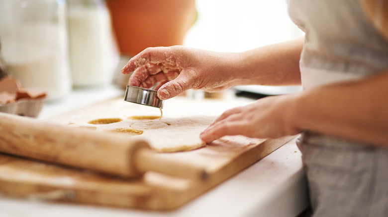 Person cutting out biscuits with cutter