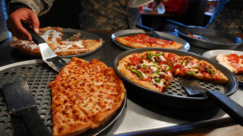 A guest selecting pizza from a buffet