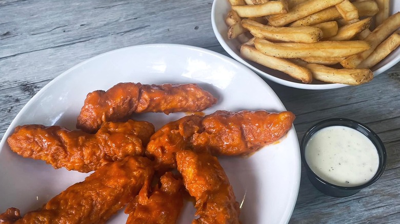 Chicken strips and fries on plate