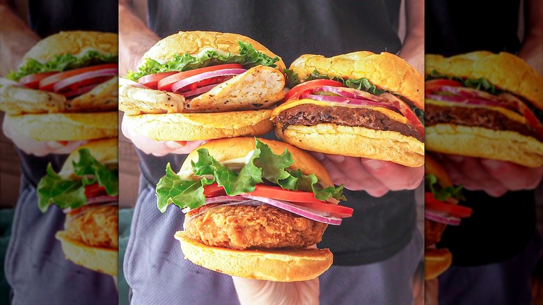 Person holding fast food burgers
