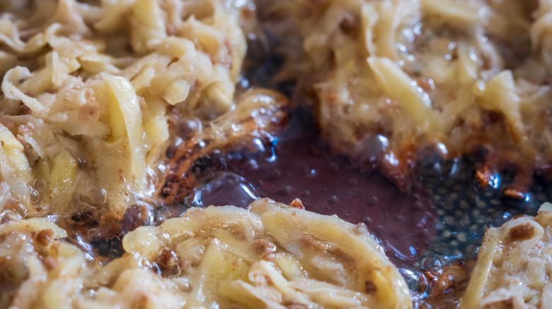 close up of hash browns frying in pan