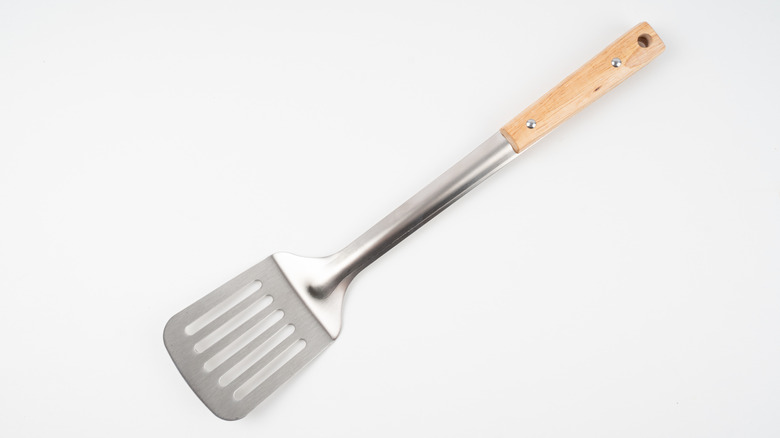 square metal spatula with wooden handle on white background