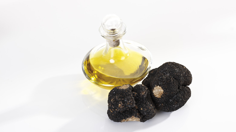 black truffles next to glass container of truffle oil