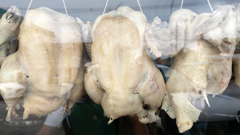 boiled chicken hanging in market