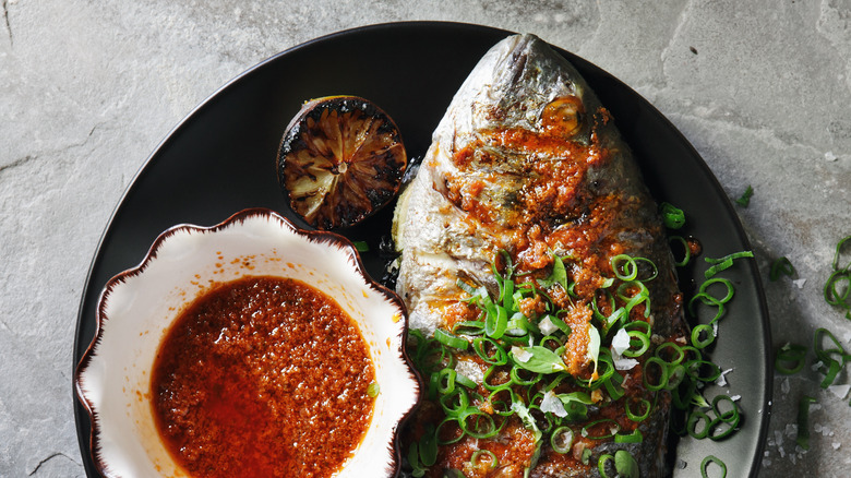 whole cooked fish with condiments