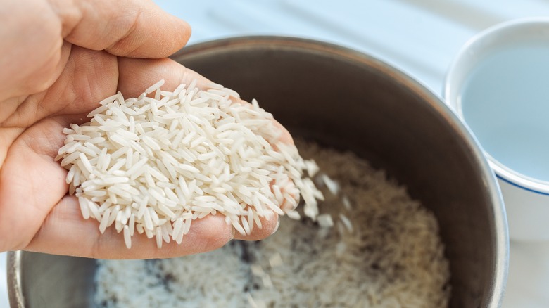 hands rinsing rice in water