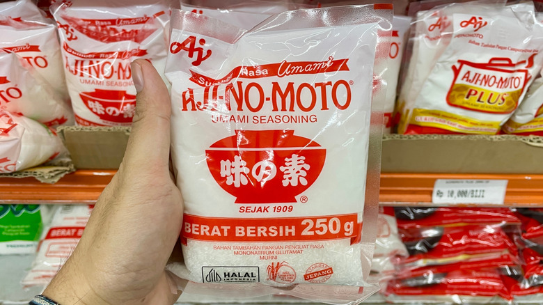 person holding a bag of Ajinomoto MSG umami seasoning