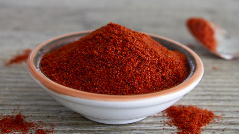 bright red paprika sitting in a dish on a gray surface