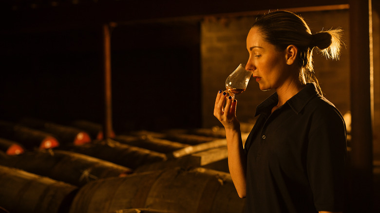 Woman sniffing a glass of whiskey
