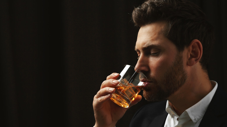Man sipping a glass of whiskey