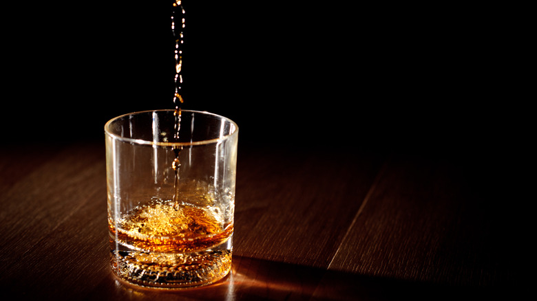 Line of whiskey falling into glass
