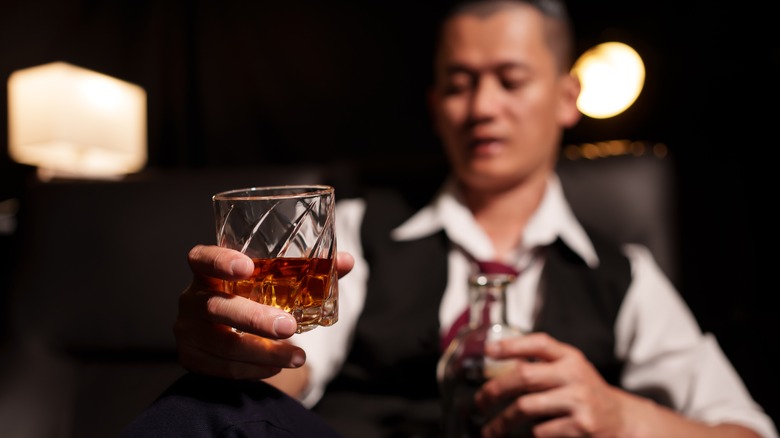 Bartender holding up a glass of whiskey