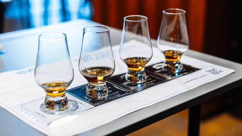 A line of four whiskey glasses at a tasting