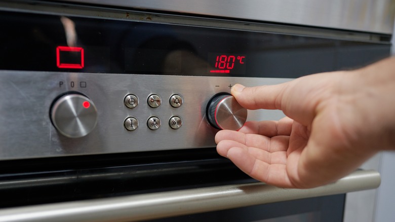 Person adjusting oven