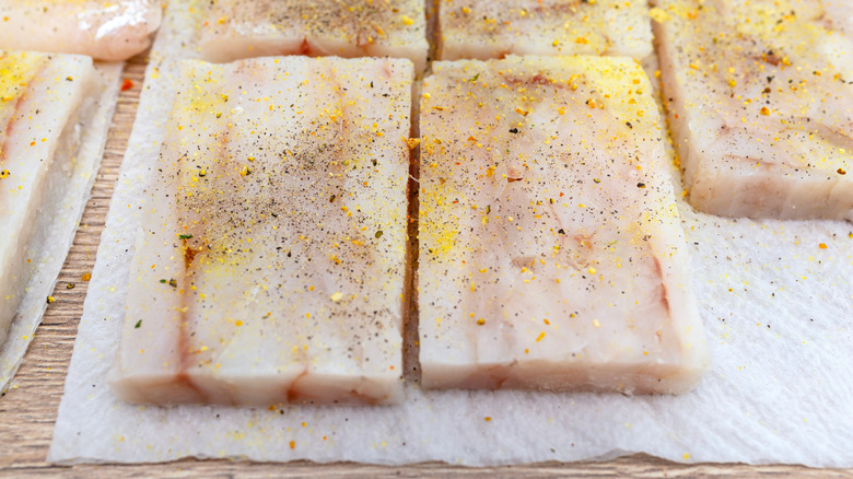 Square cod fillets with seasoning on paper towel