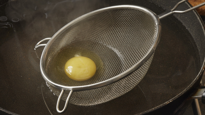 Egg in strainer and pot