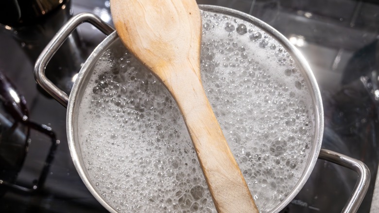 Water boiling with wooden spoon