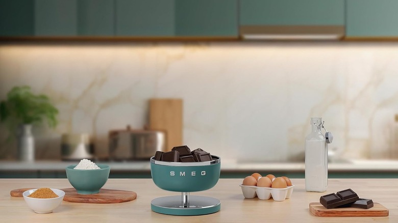 A SMEG digital scale weighing chocolate on a countertop with other ingredients
