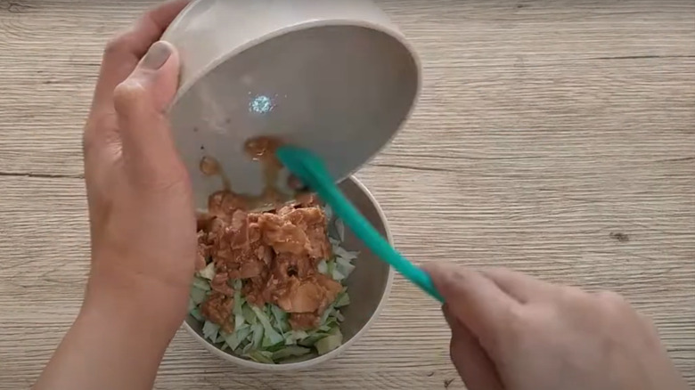 Hand making tuna and coleslaw salad