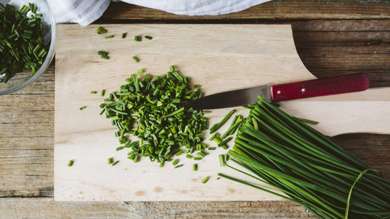 chives sliced on cutting board with knife