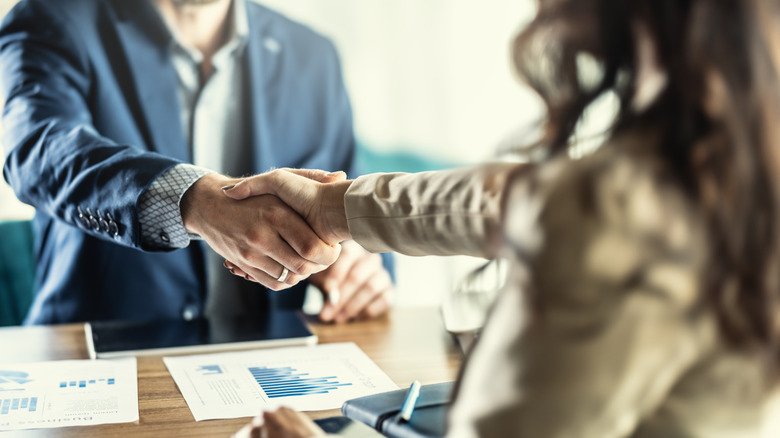 close up handshake over desk