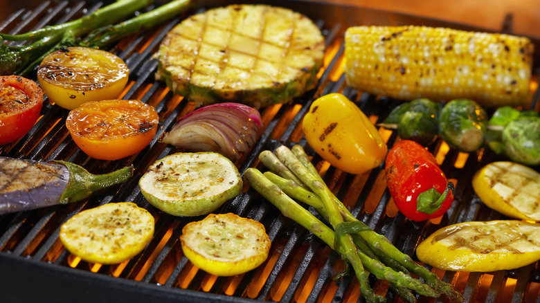 A variety of vegetables roasting on the grill with char marks