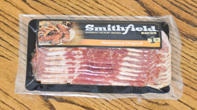 A package of Smithfield hickory smoked bacon on a wooden table