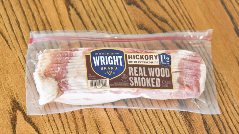 A package of Wright hickory smoked thick cut bacon on a wooden table