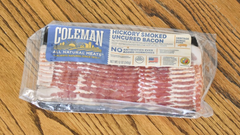 A package of Coleman hickory smoked uncured bacon on a wooden table