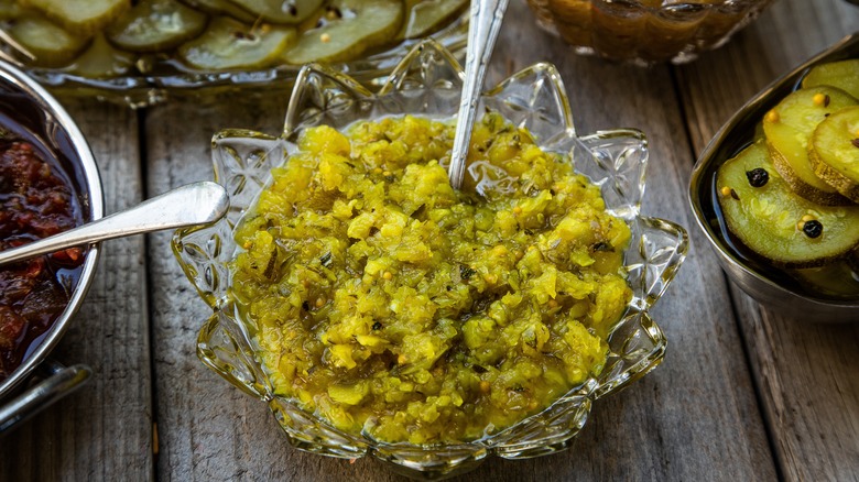 A bowl of pickle relish with a serving spoon