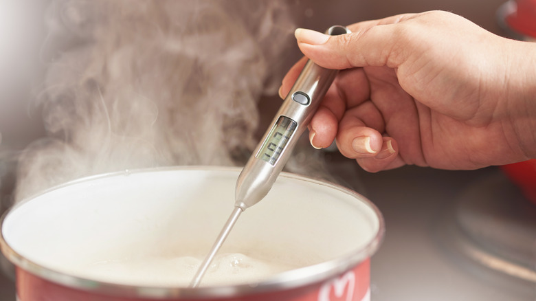 Woman measuring temperature of water