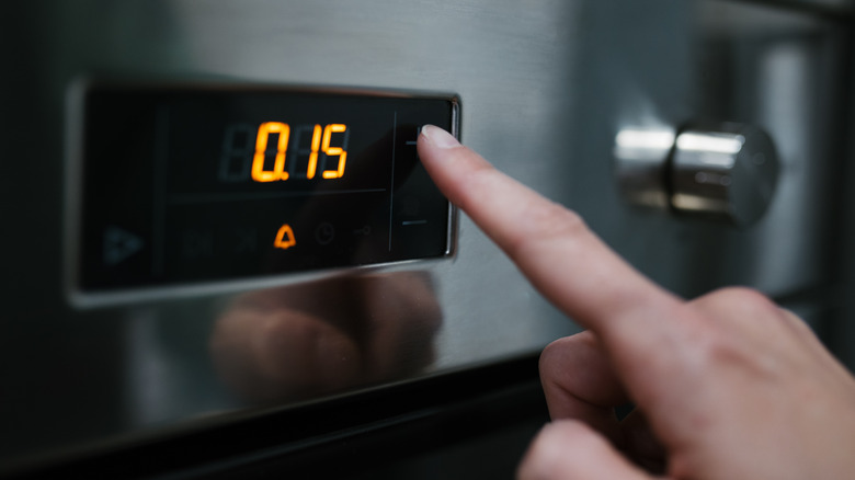 Woman setting kitchen timer