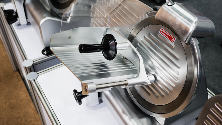 An electric meat slicer in a restaurant kitchen