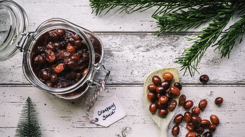 holiday cranberry sauce in jar next to fresh cranberries