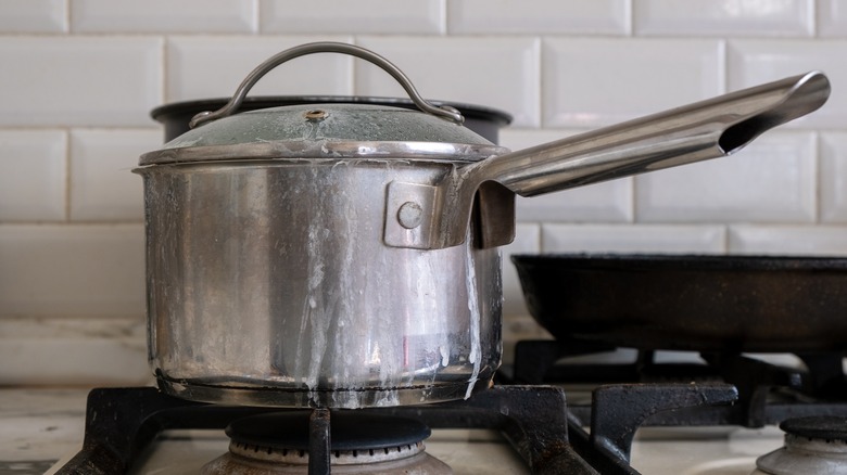 silver pot with handle on stove