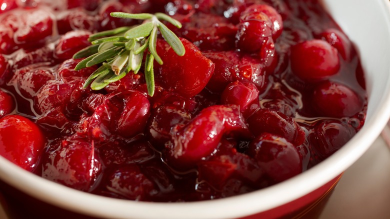 white bowl of cranberry sauce with rosemary