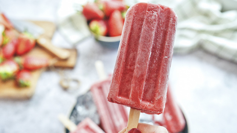 Woman holding strawberry popsicle