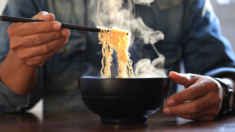 Eating bowl of instant noodles