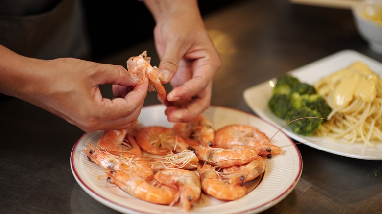 Hands peeling shrimp