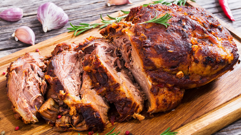 A partially cut roasted pork shoulder