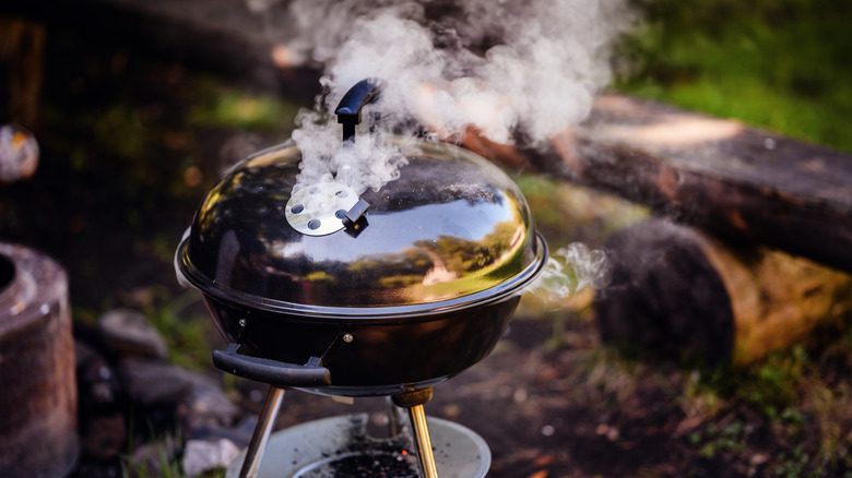 A closed grill with smoke coming out of the top