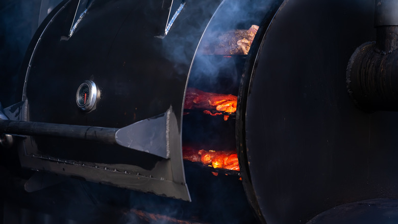 A smoker with a temperature gauge built in on the outside cover