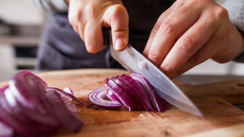 Woman thinly slicing onions