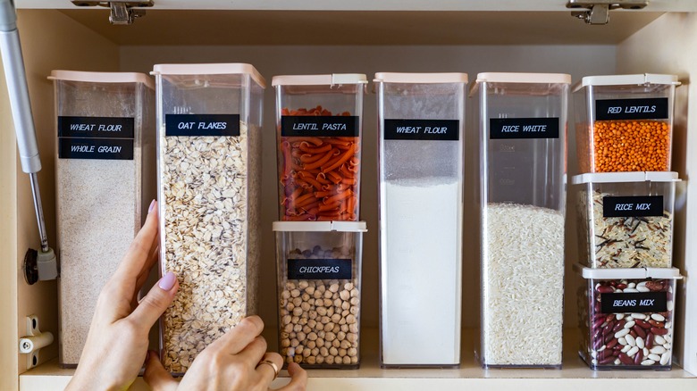 Hands organizing pantry foods