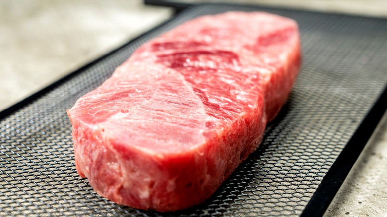 Steak meat on baking sheet