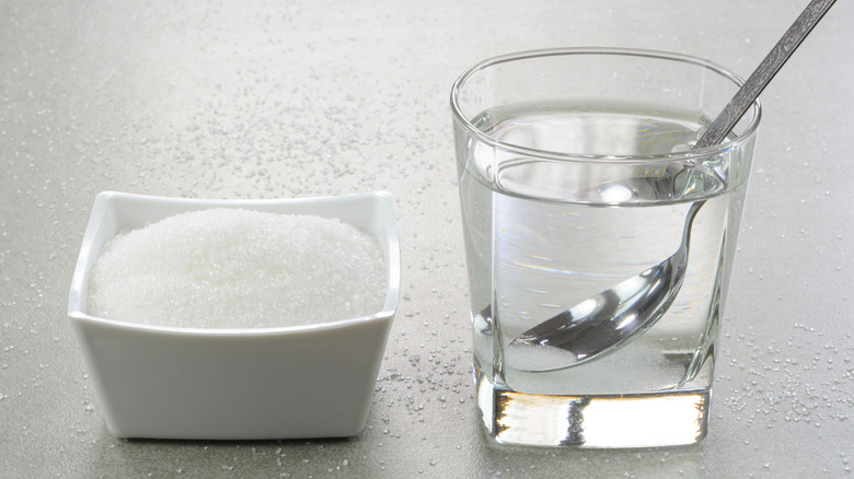 Glass of water and sugar on counter