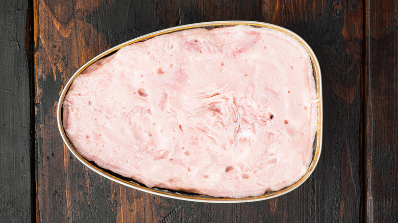 Open canned ham on table