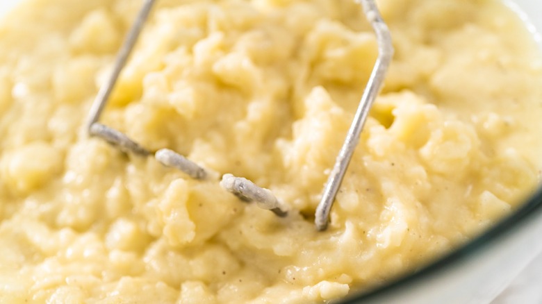 Close up of potatoes being mashed