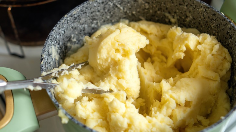 Potatoes in a pan being mashed